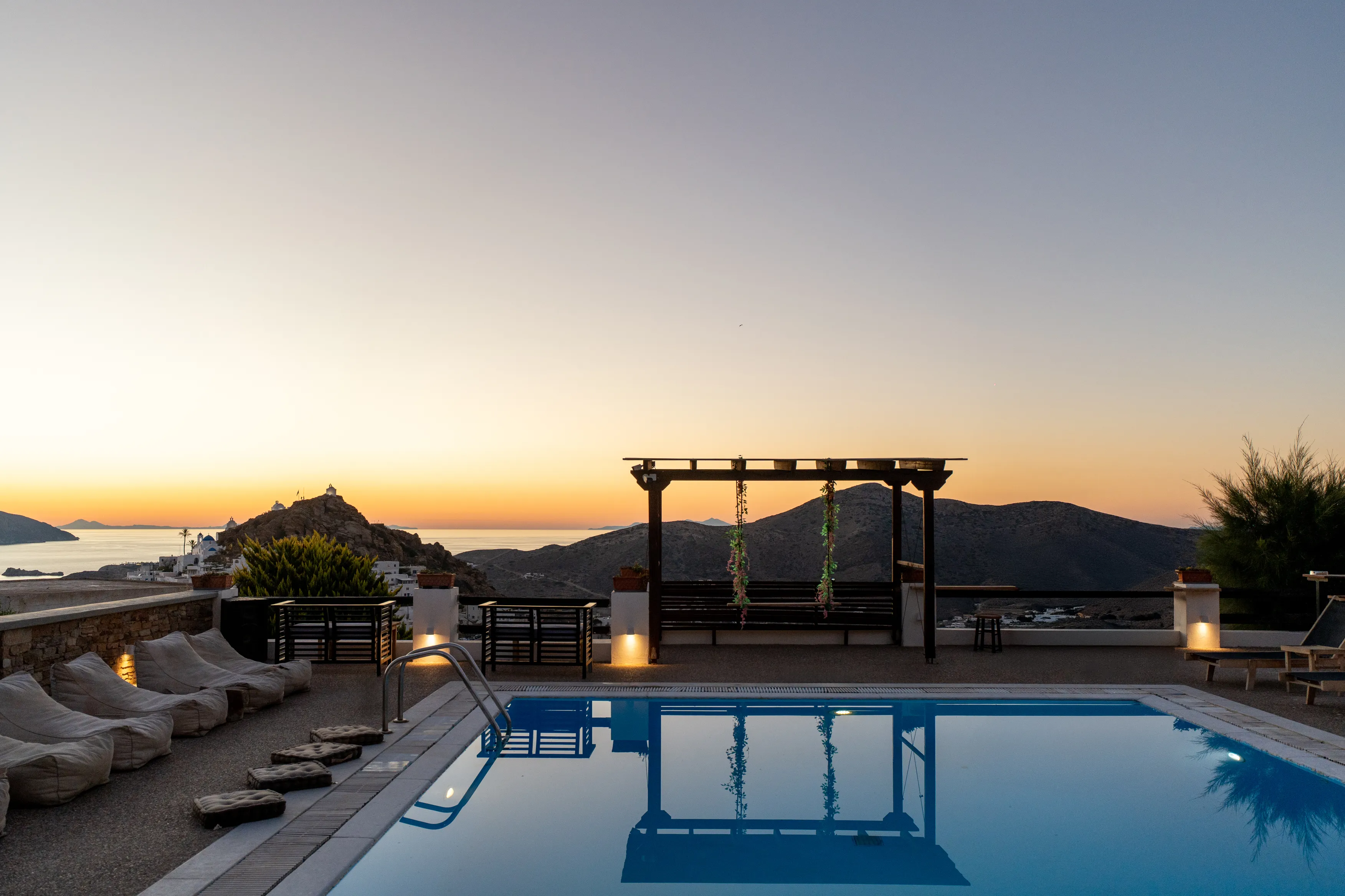 SkalaSunset pool area at sunset with sun loungers and sea view in Ios