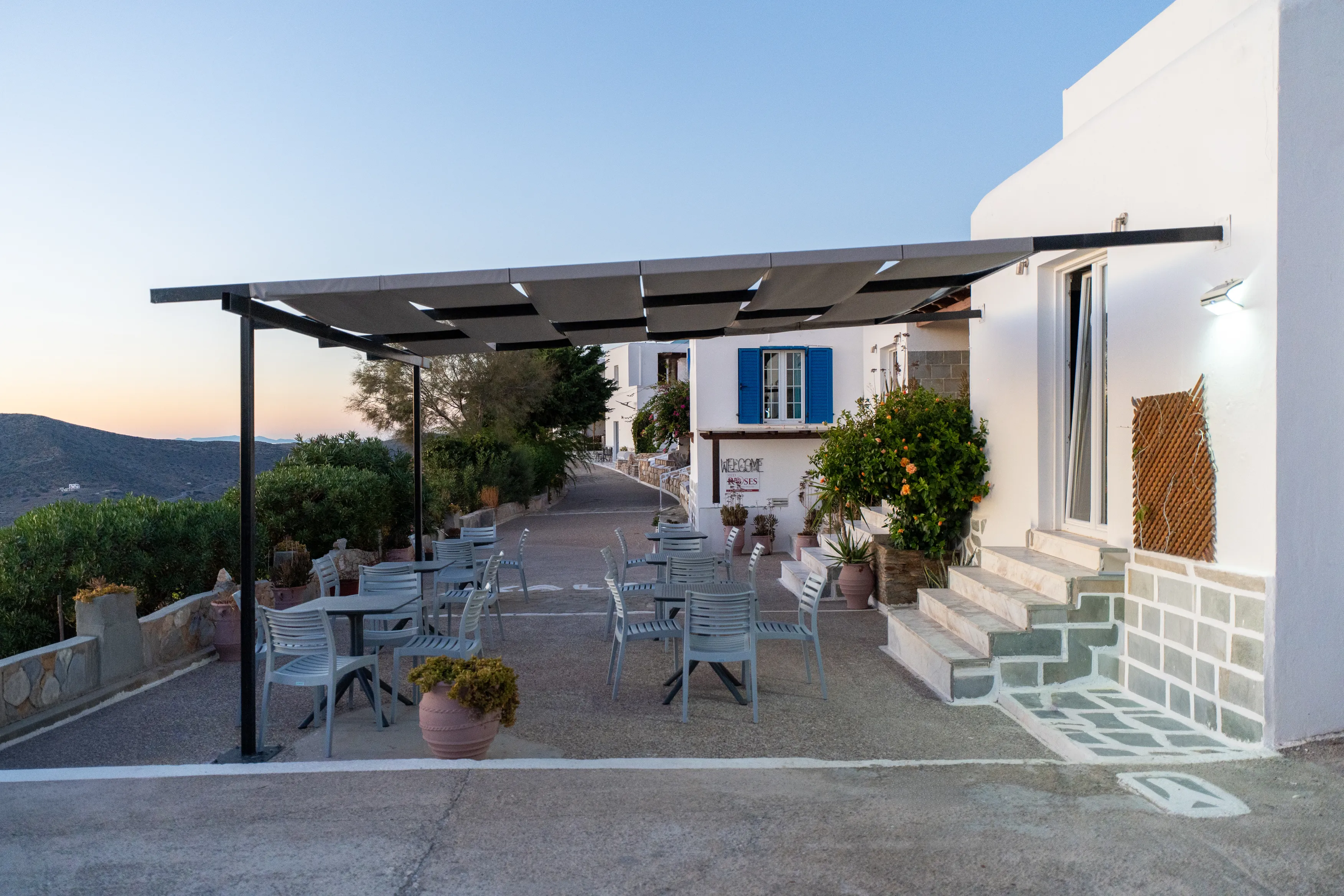 SkalaSunset hotel exterior terrace with outdoor tables and white Cycladic architecture