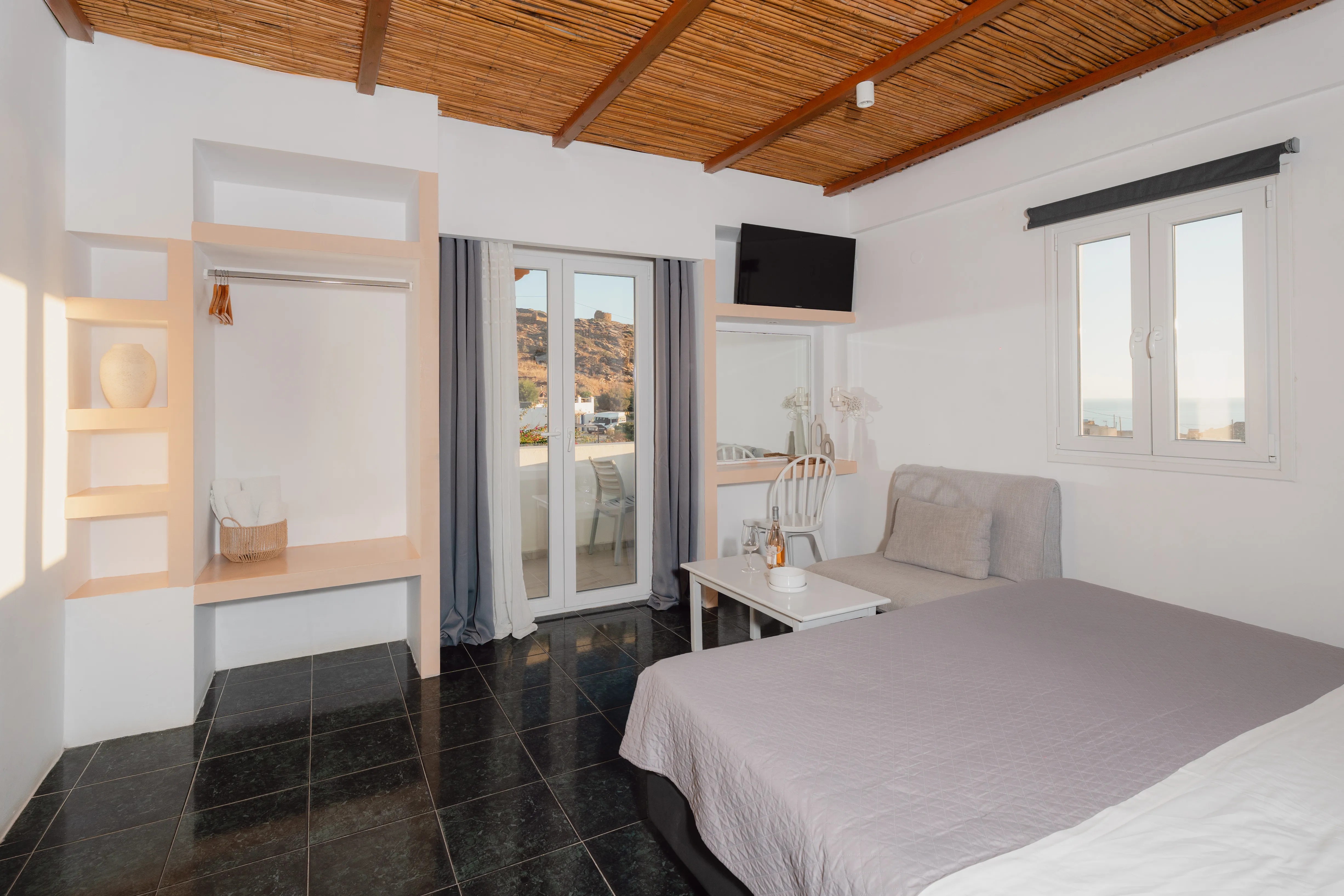 SkalaSunset triple room interior with terrace doors and compact kitchenette